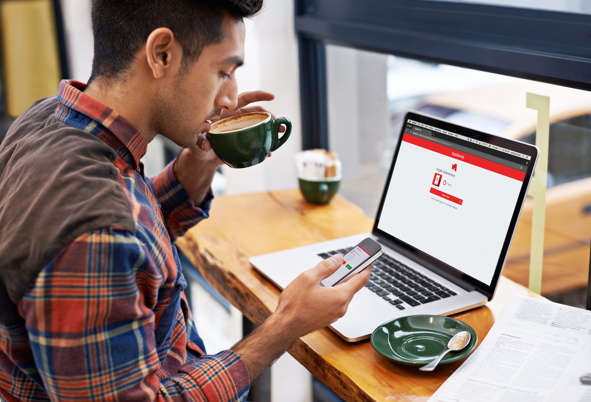 man working on phone sipping coffee