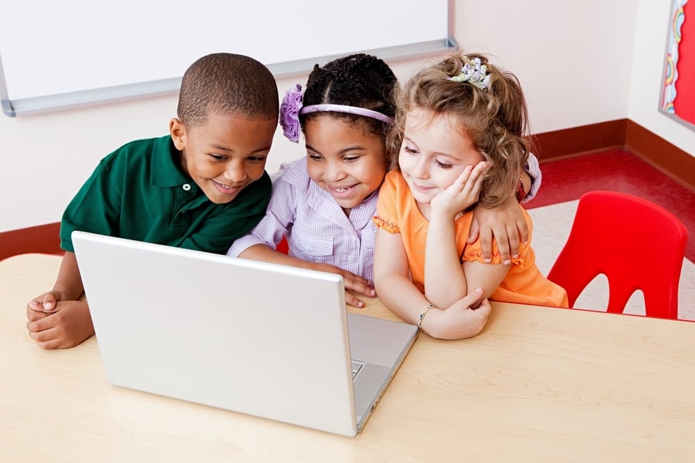 Three-children-looking-at-a-laptop-together