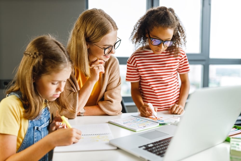 female-tutor-helping-two-elementary-school-girls