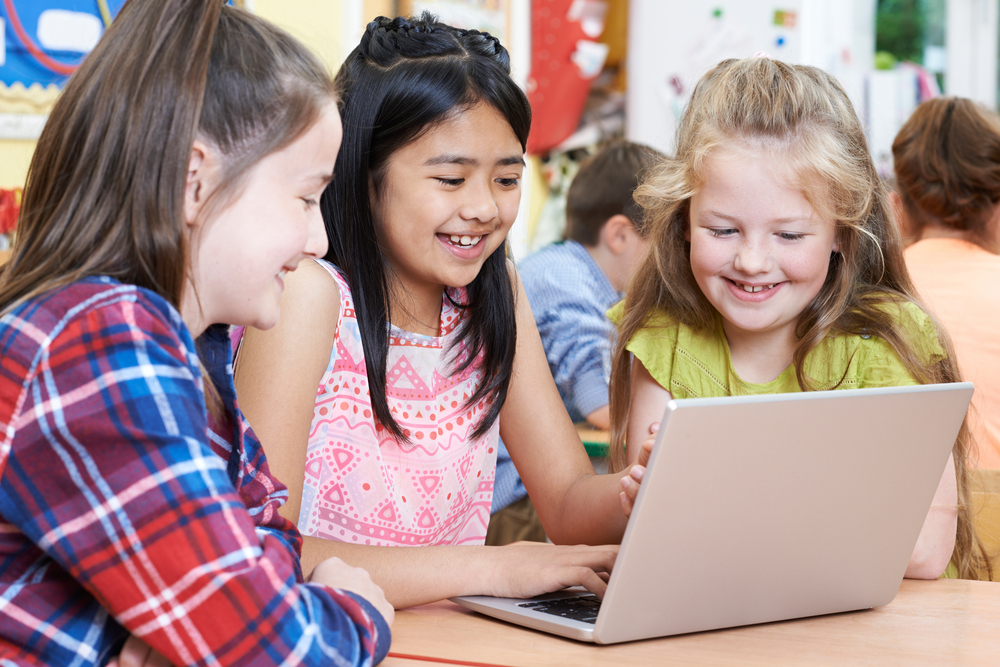 Group-Of-Elementary-School-Children-Working-Together-In-Computer-Class